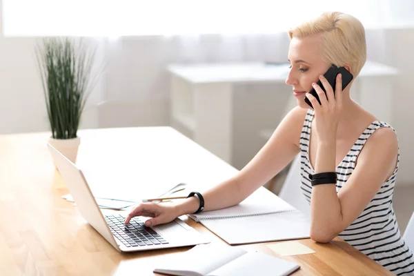 Woman talking on phone and checking information — Stock Photo, Image