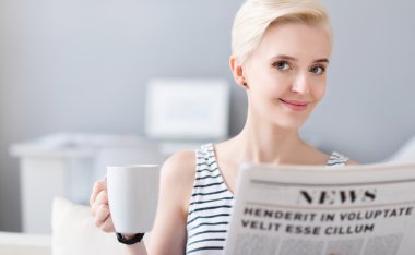 gülümseyen bir gazete okuyan kadın