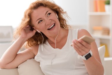 Neşeli kadın müzik dinliyor.