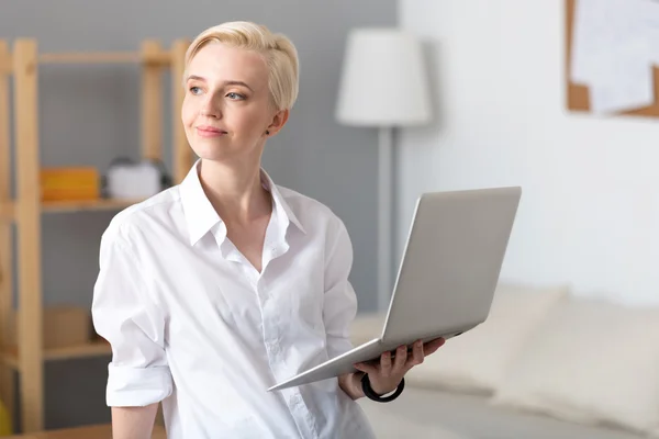 Woman smiling and holding laptop — Stock Photo, Image