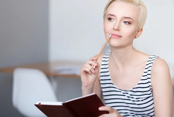 Donna guardando da parte e tenendo diario — Foto Stock