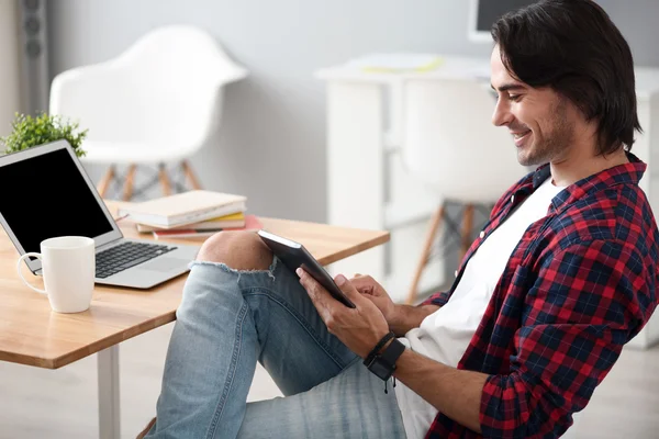 Homem alegre agradável usando tablet — Fotografia de Stock