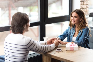 Kafede oturan hoş gülümseyen çift