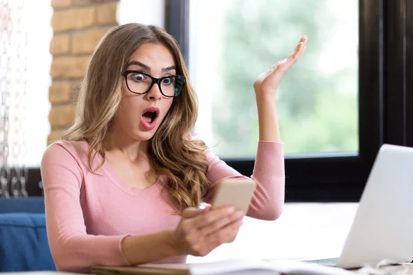 Emotionele vrouw zittend aan tafel — Stockfoto