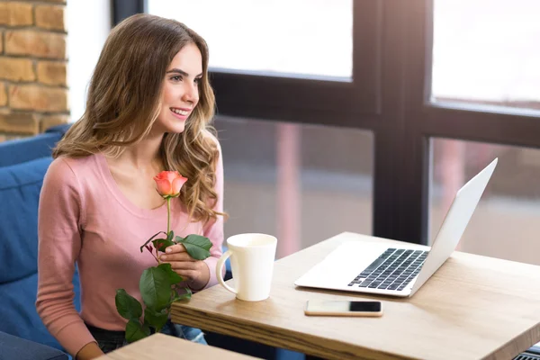 Deliziosa donna sorridente seduta a tavola — Foto Stock