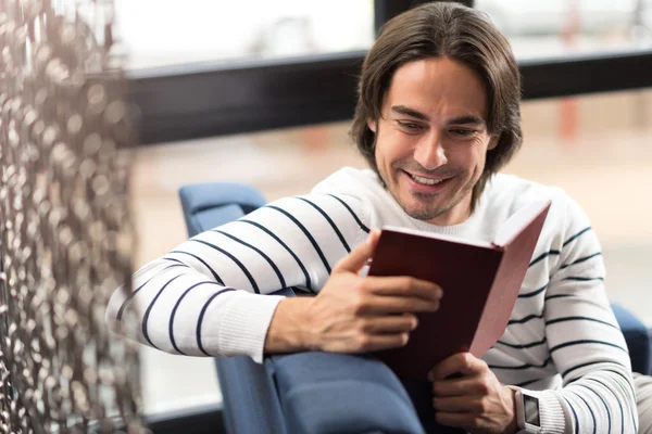 Веселый человек, читающий книгу — стоковое фото