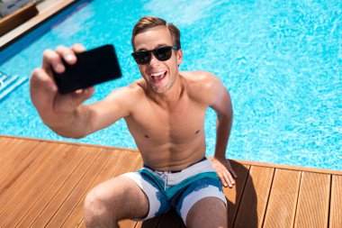 Yüzme havuzu yakınında selfie çeken çok mutlu adam