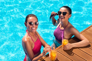 Bir yüzme havuzunda dinlenen neşeli arkadaşlar