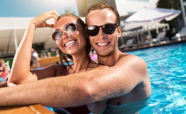 Havuzda yüzen neşeli bir çift