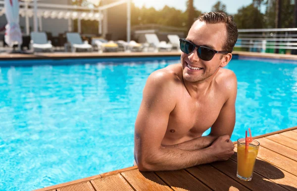 Hombre guapo positivo descansando en la piscina — Foto de Stock