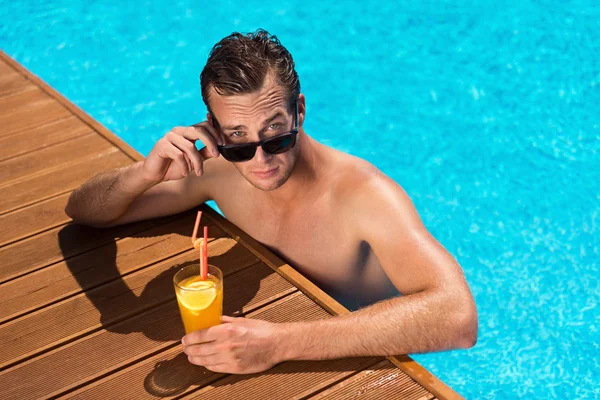 Agradable hombre relajándose en la piscina — Foto de Stock