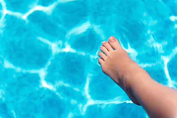 Ευχάριστη γυναίκα κρατώντας το πόδι στην πισίνα — Φωτογραφία Αρχείου