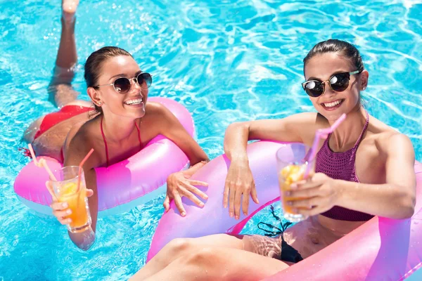 Amigos alegres descansando en una piscina — Foto de Stock