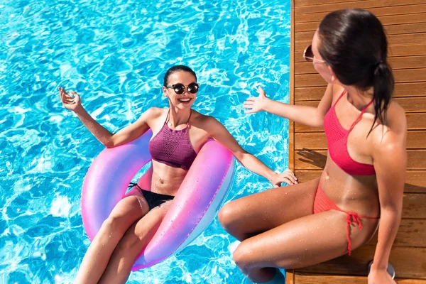 Fröhliche Freunde, die sich in einem Schwimmbad ausruhen — Stockfoto