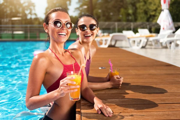 Bir yüzme havuzunda dinlenen neşeli arkadaşlar