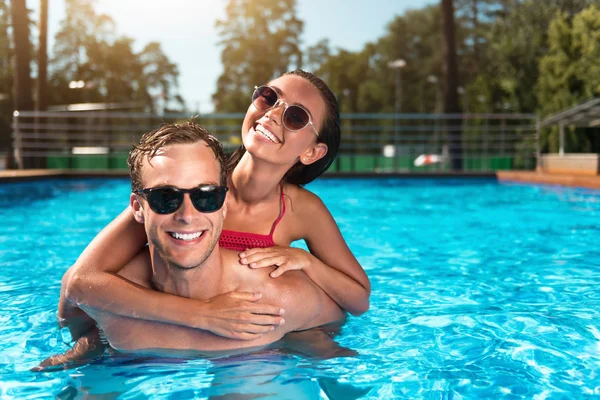 Pareja alegre nadando en una piscina — Foto de Stock