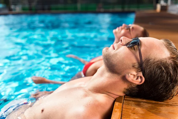 Pareja relajada descansando en la piscina — Foto de Stock