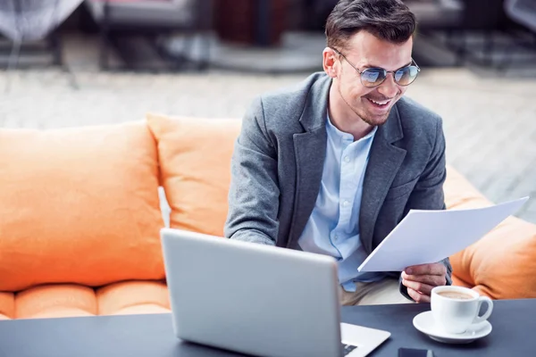 Fröhlicher Geschäftsmann sitzt im Café — Stockfoto