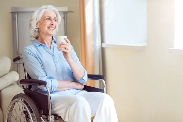 Mujer mayor en silla de ruedas en la sala — Foto de Stock