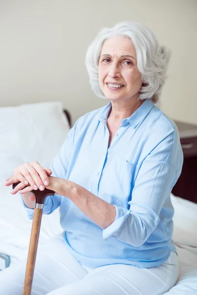 Mujer mayor positiva sentada — Foto de Stock