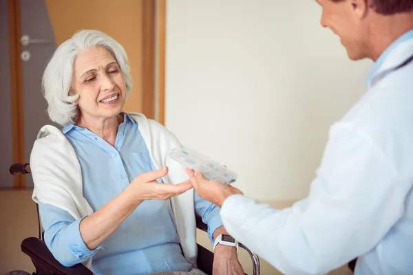 Medico dando pillole il suo paziente — Foto Stock