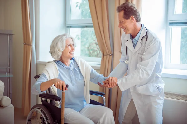 Nice doctor supporting senior woman — Stock Photo, Image