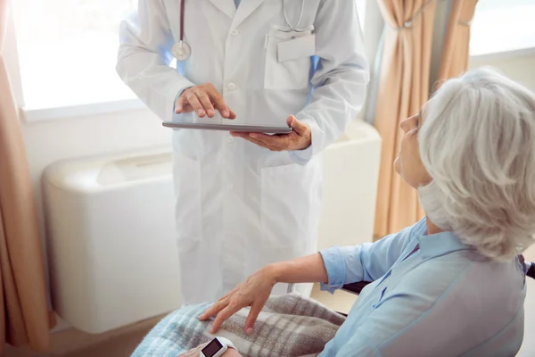 Mujer mayor en silla de ruedas con médico — Foto de Stock