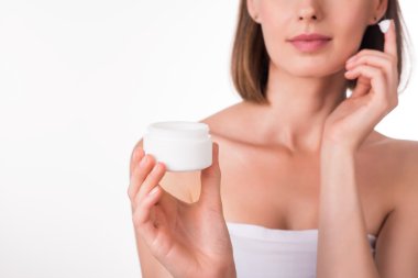 Genç kadın krem sürüyor.