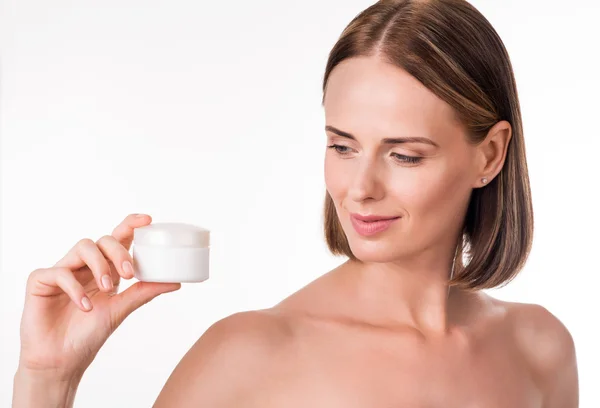 Pretty young woman holding cream — Stock Photo, Image