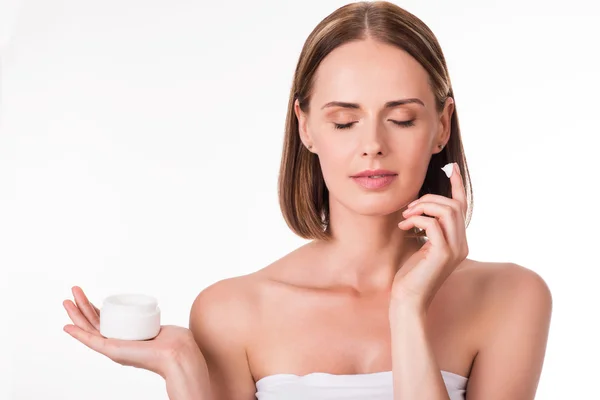 Mujer joven aplicando cosméticos —  Fotos de Stock