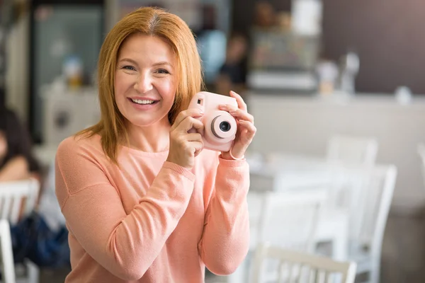 Радостная женщина с фотокамерой — стоковое фото