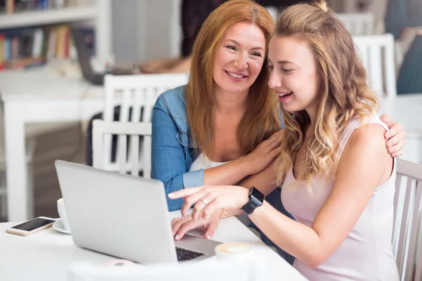 Mujer positiva sentada a la mesa con su hija —  Fotos de Stock