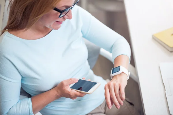 Fröhliche Seniorin sitzt am Tisch — Stockfoto