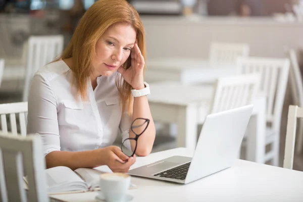 Moody senior mujer sentado a la mesa — Foto de Stock