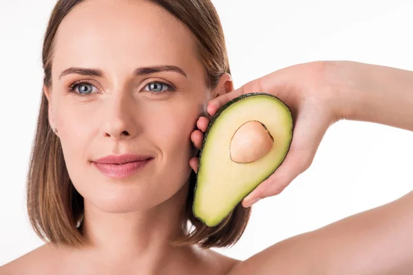 Cute young woman holding avocado — Stock Photo, Image