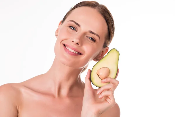 Hermosa joven sosteniendo parte del aguacate — Foto de Stock