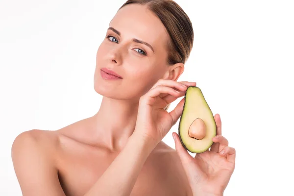 Delighted young woman holding part of avocado — Stock Photo, Image