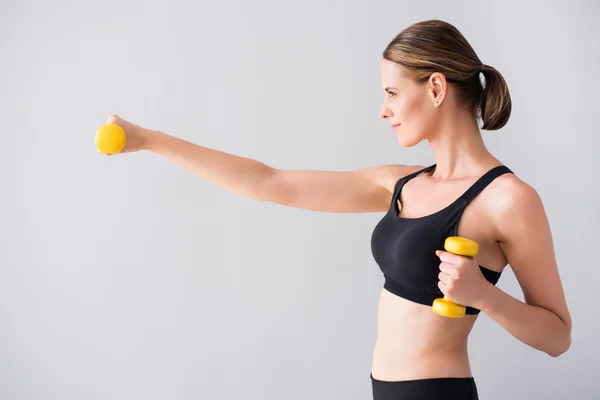 Confident young woman with dumb bells — Stock Photo, Image
