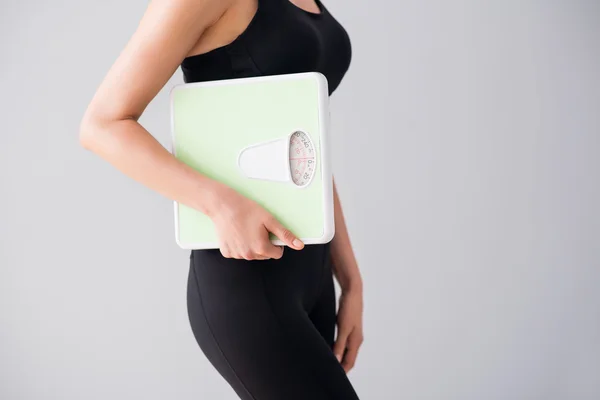 Young woman holding scales — Stock Photo, Image