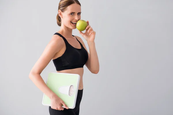 Mladá žena drží váhy a apple — Stock fotografie