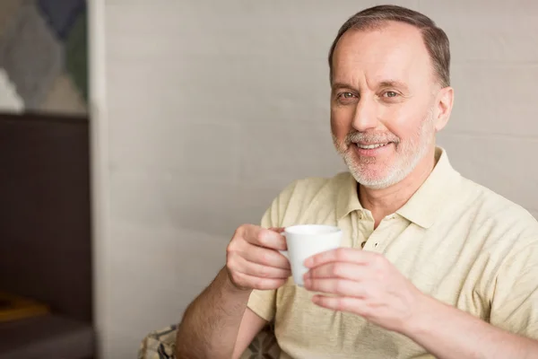 Веселый пожилой человек пьет кофе — стоковое фото