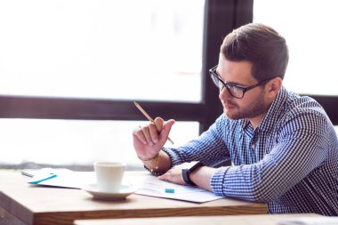 Düşünceli ciddi adam masada çalışıyor