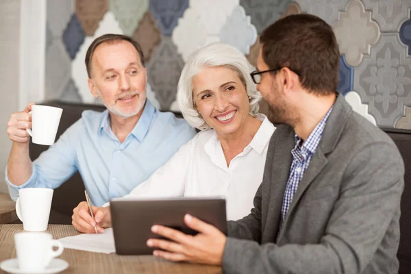 Alegre pareja de ancianos hablando con el gerente de ventas —  Fotos de Stock