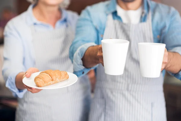 Garçons agradáveis segurando croissants e chá — Fotografia de Stock