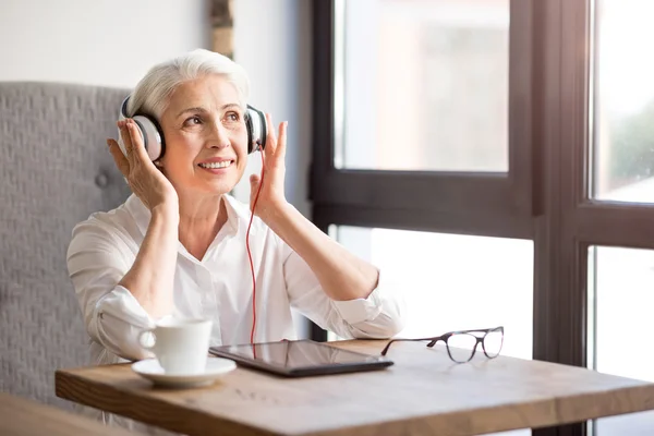Mujer mayor positiva escuchando música —  Fotos de Stock