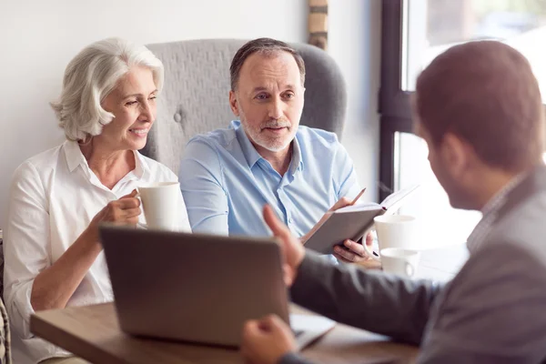 Positive senior couple talking with sales manager — Stock Photo, Image