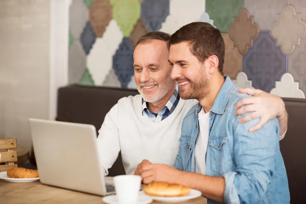 Homme joyeux et son petit-fils adulte reposant dans le café — Photo