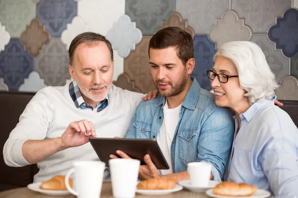 Positiver Mann und seine Großeltern ruhen sich im Café aus — Stockfoto