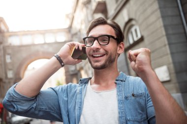 Mutlu genç adam bir telefon görüşmesi yapıyor