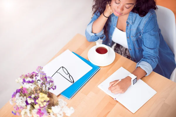 Aangenaam geïnspireerde vrouw zittend aan tafel — Stockfoto